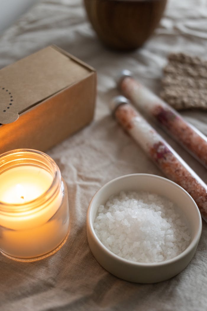 Warm and calming aromatherapy setup featuring candle, salt, and natural elements.